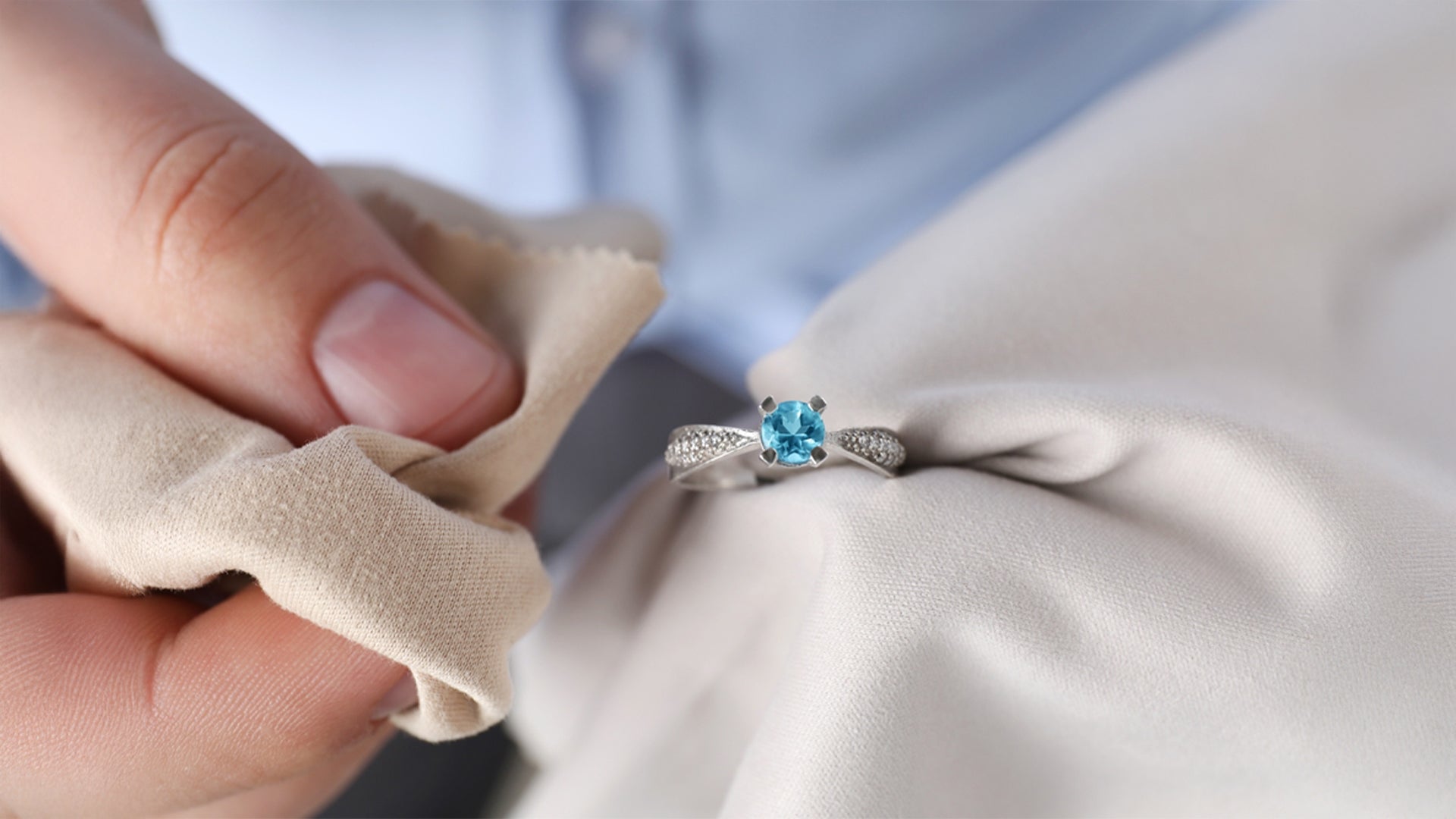 A person elegantly holds a stunning blue diamond ring, showcasing its brilliance and exquisite design.